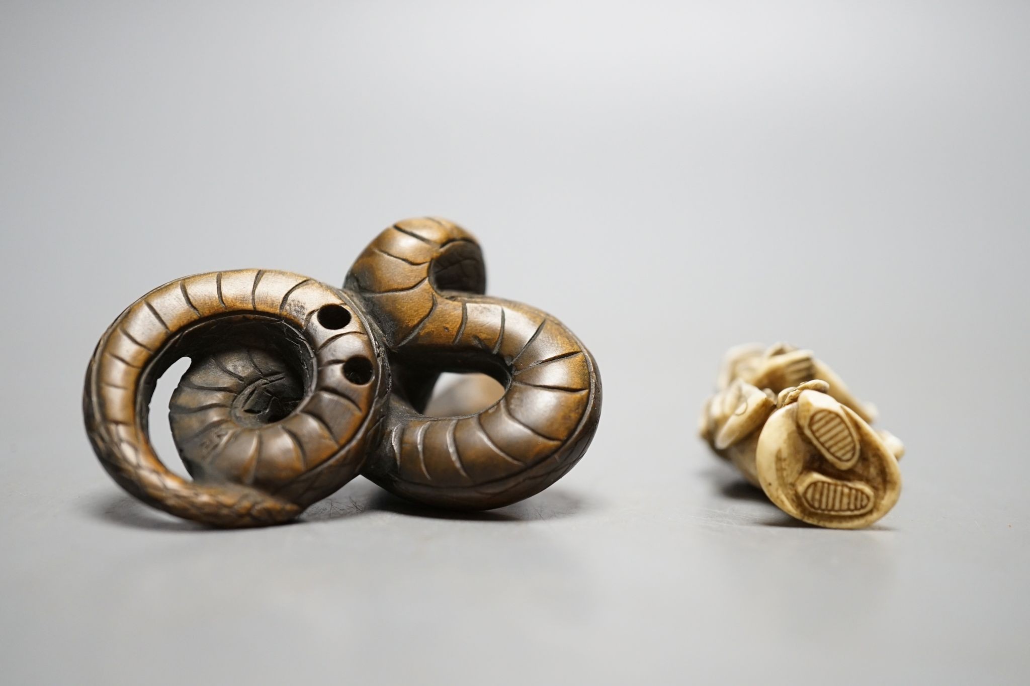 A Japanese ivory figure of a sage and a signed carved wood snake netsuke, 5cm long